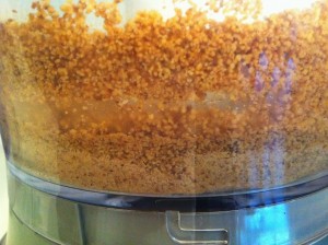 crushed almonds in food processor on side view