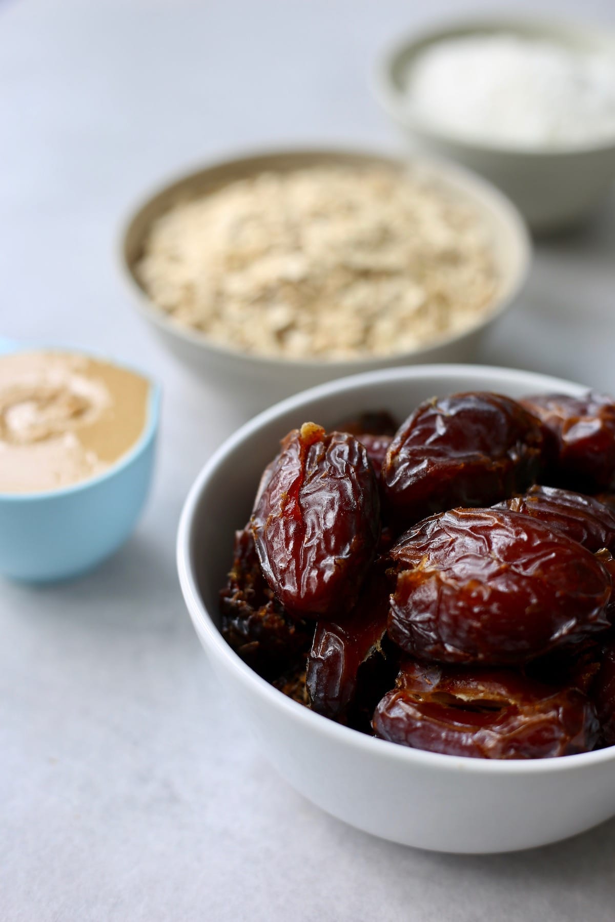 bowls full of dates, oats, desiccated coconut and nut butter