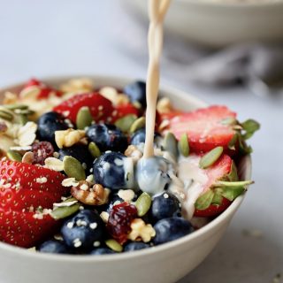 milk being poured onto fruit cereal