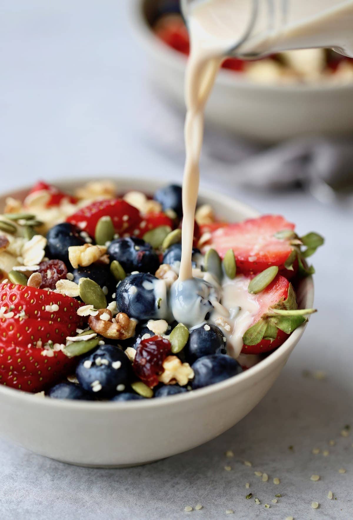 milk being poured onto fruit cereal