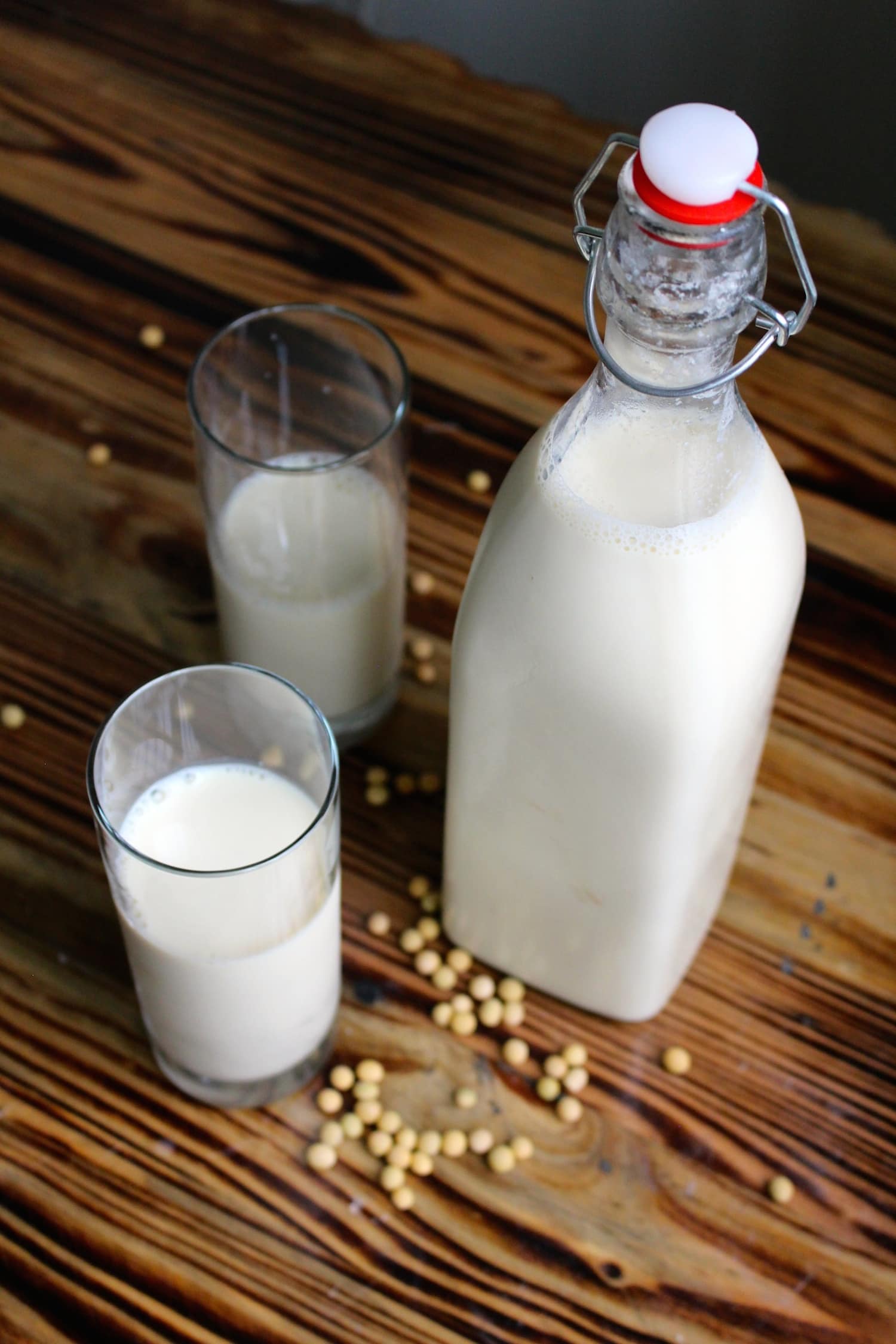 a jar and two glasses full of homemade soy milk