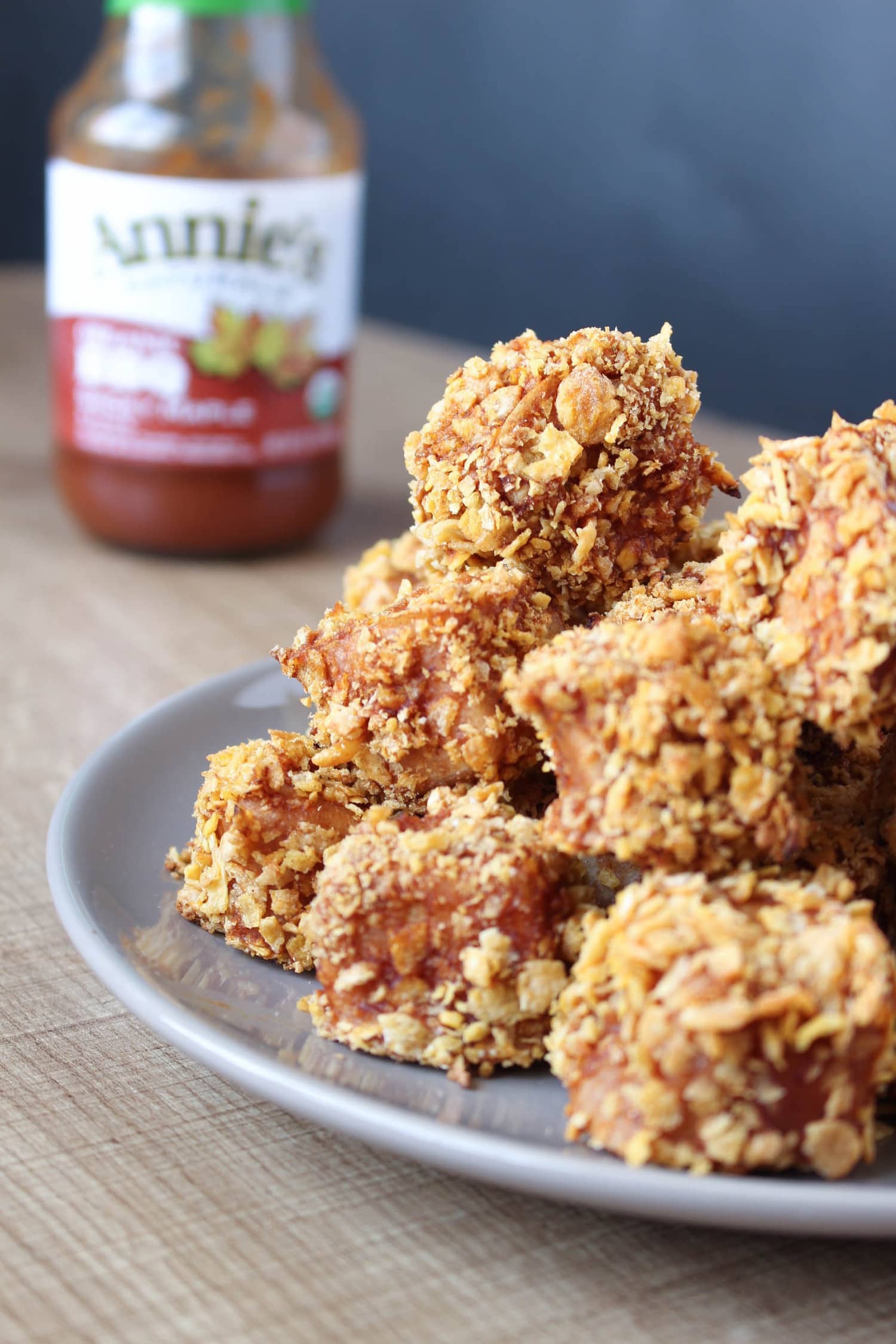 side view BBQ Baked Tofu nuggets on a plate with BBQ sauce in background