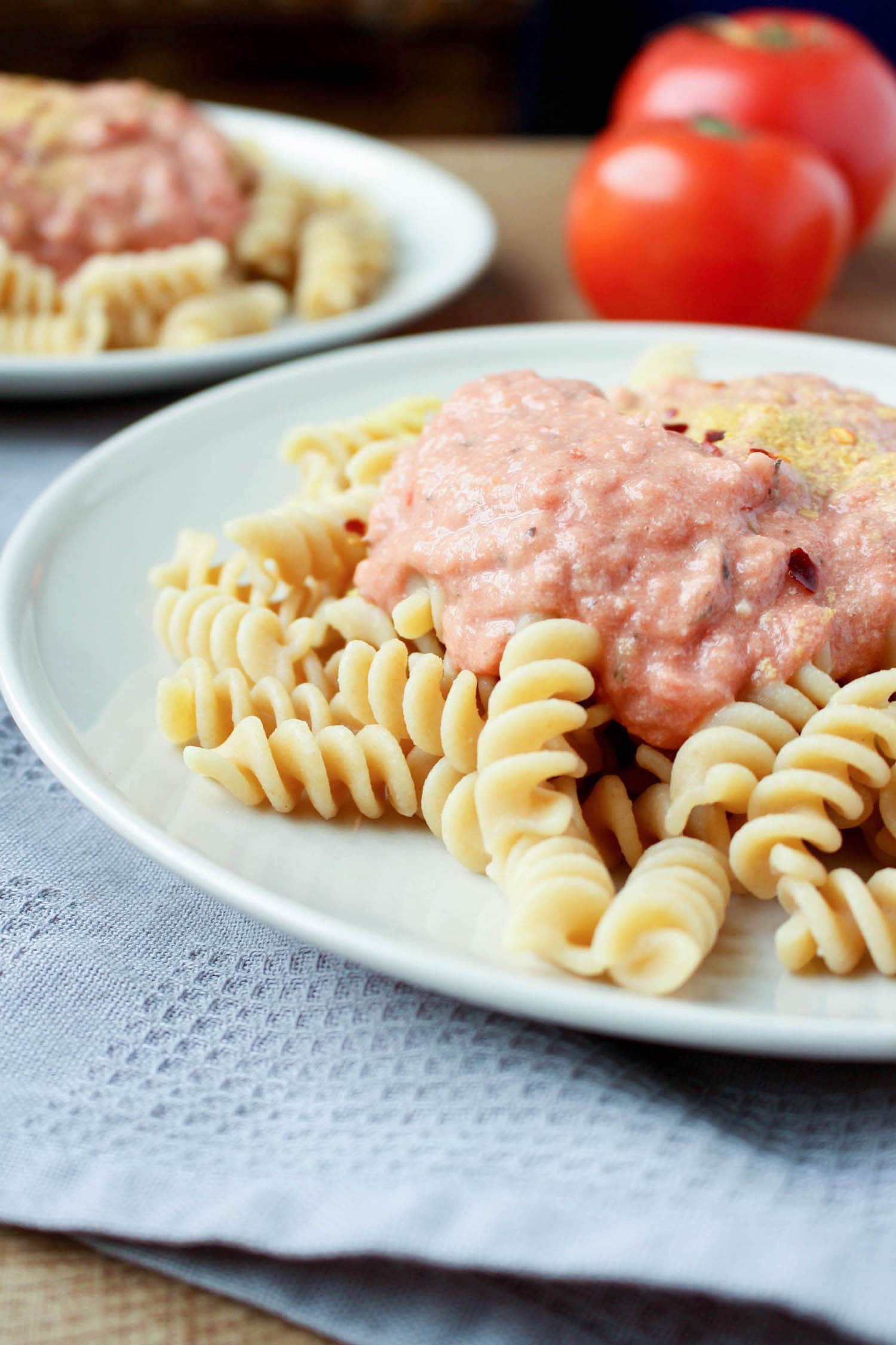 a side view of creamy pink pasta sauce overtop of rotini pasta