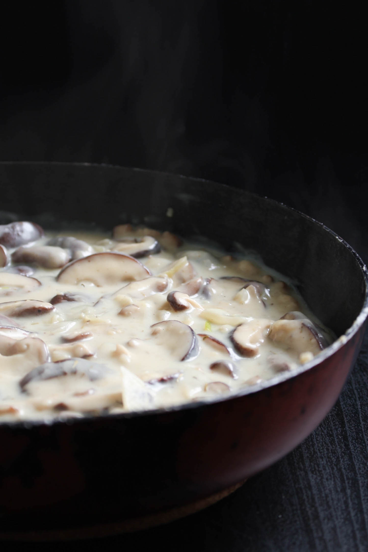 Creamy dairy-free mushroom sauce steaming in a black skillet.