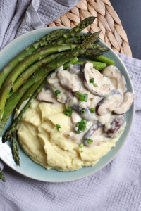 vegan mushroom gravy with potatoes and asparagus on a plate