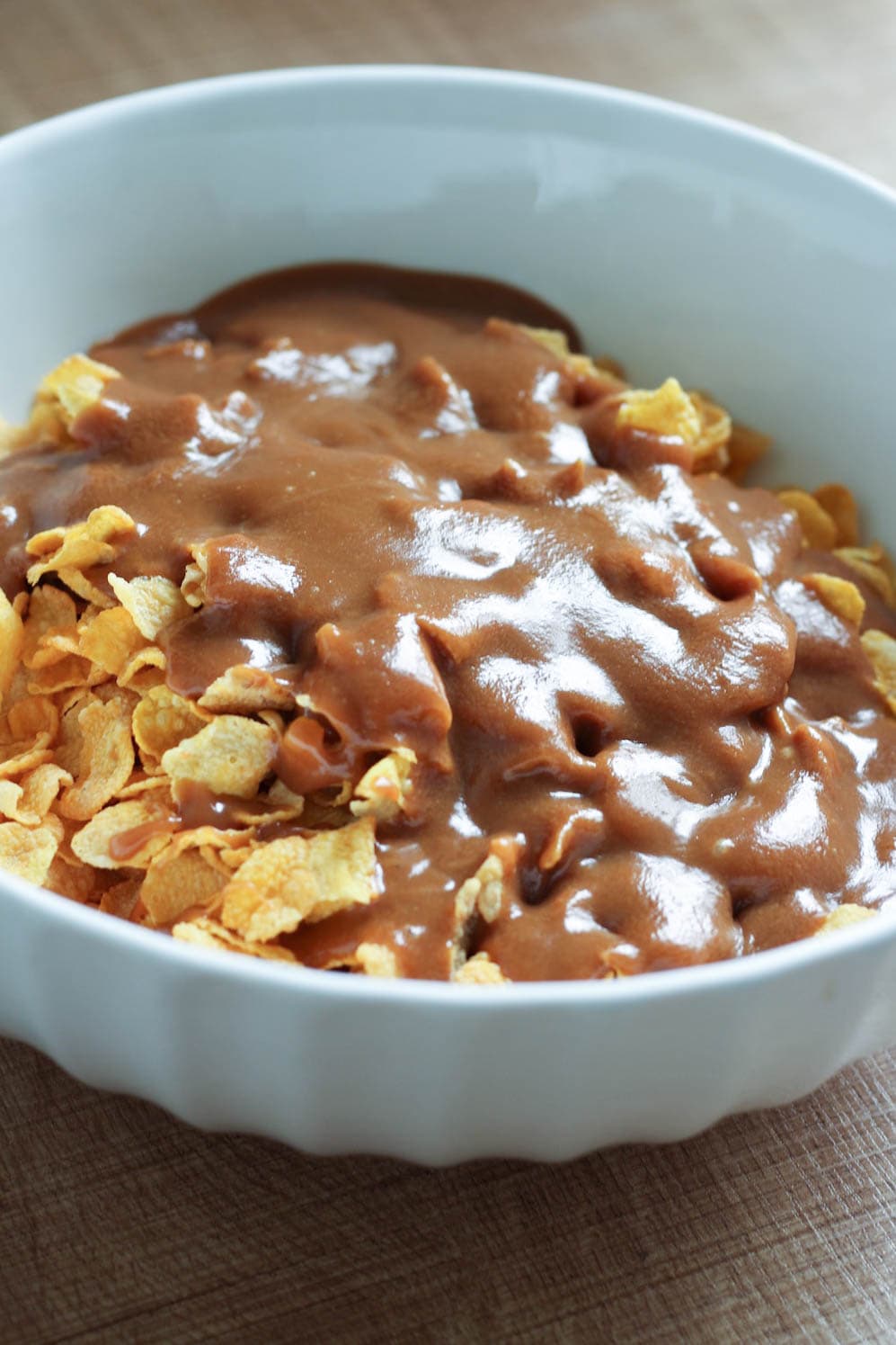 peanut butter sauce being mix into cornflakes