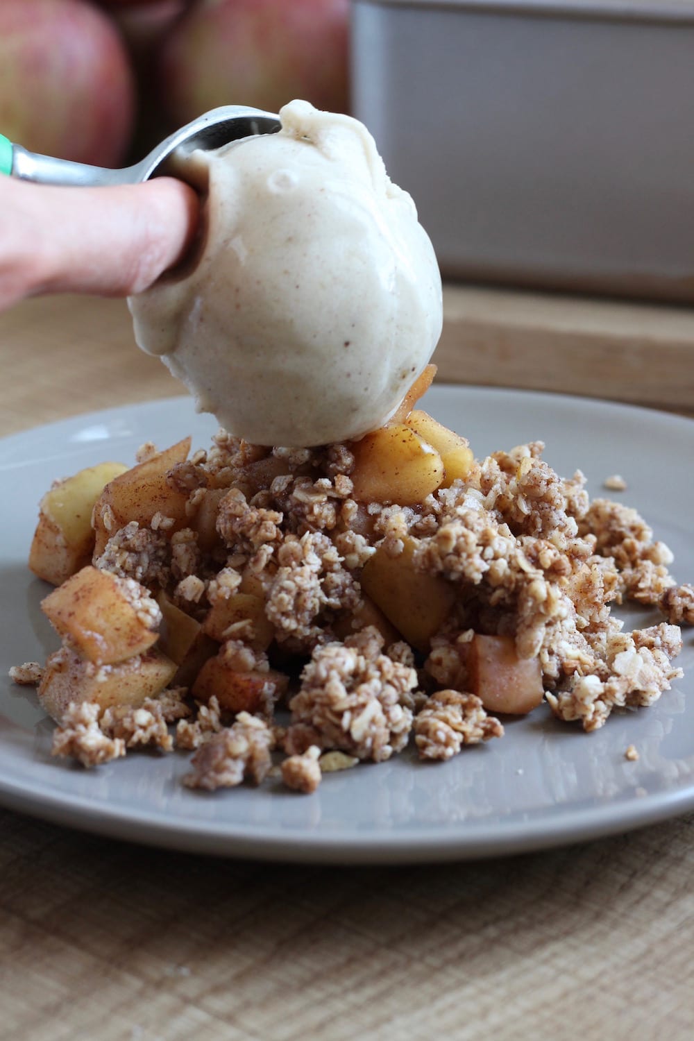 vegan banana ice cream being scooped onto vegan apple crisp