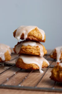 frosted vegan pumpkin cookies stacked on each other