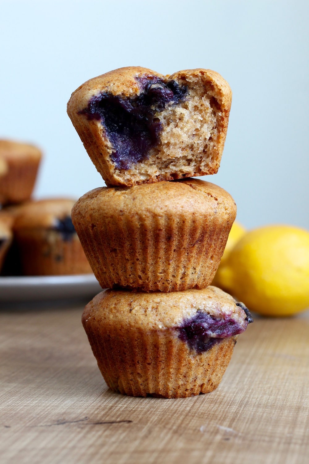 vegan lemon blueberry muffins stacked on top of each other