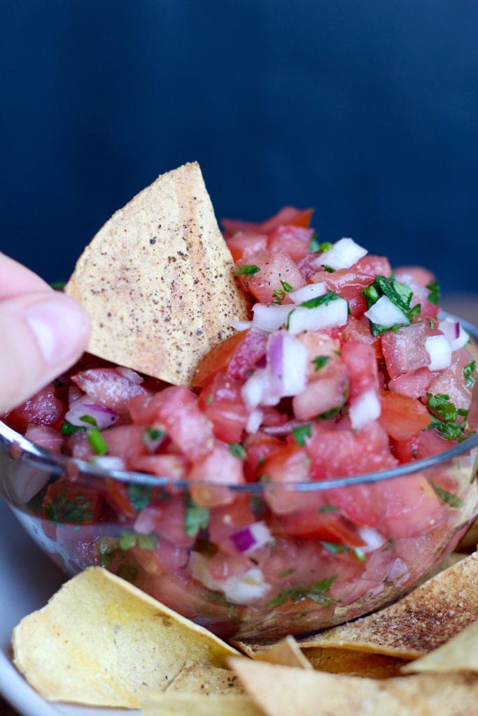 Homemade Oil Free Baked Tortilla Chips dipping into salsa
