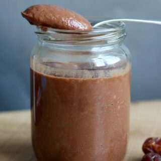 Date Sweetened Chocolate Sauce on a spoon above a jar