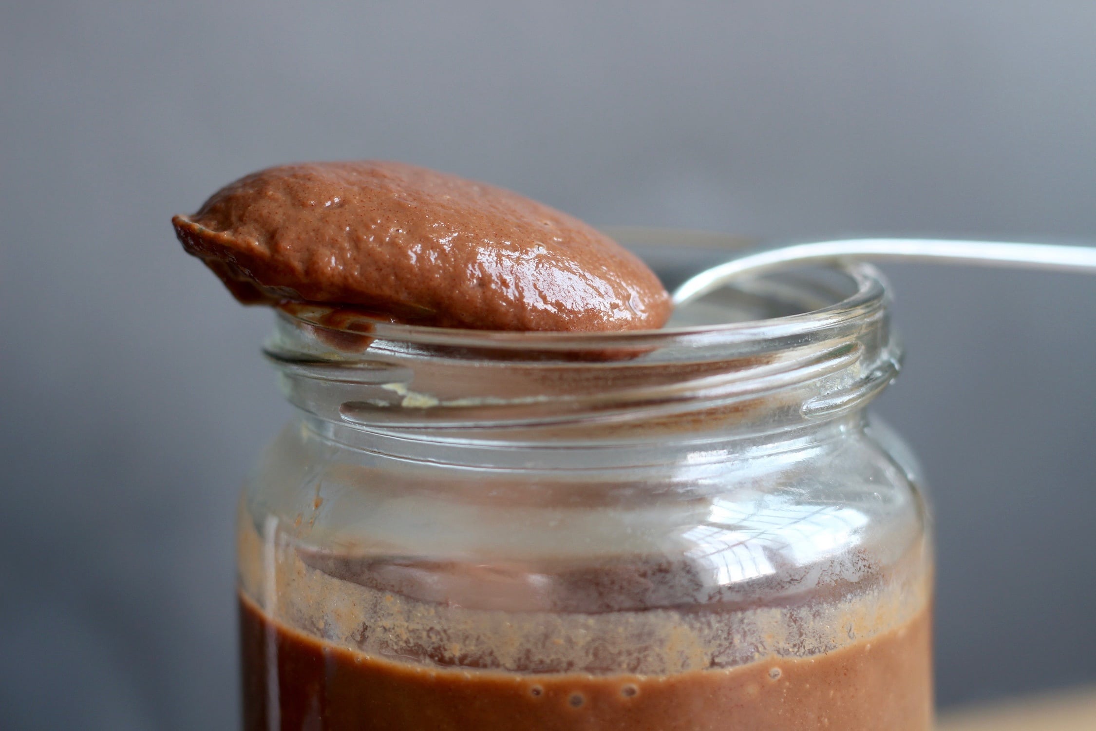 close up shot of date sweetened chocolate sauce on a spoon