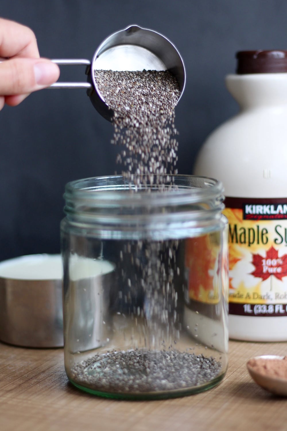 chia seeds being poured into a glass jar