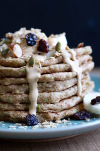 Vegan Zucchini Bread Pancakes topped with peanut butter and Granola