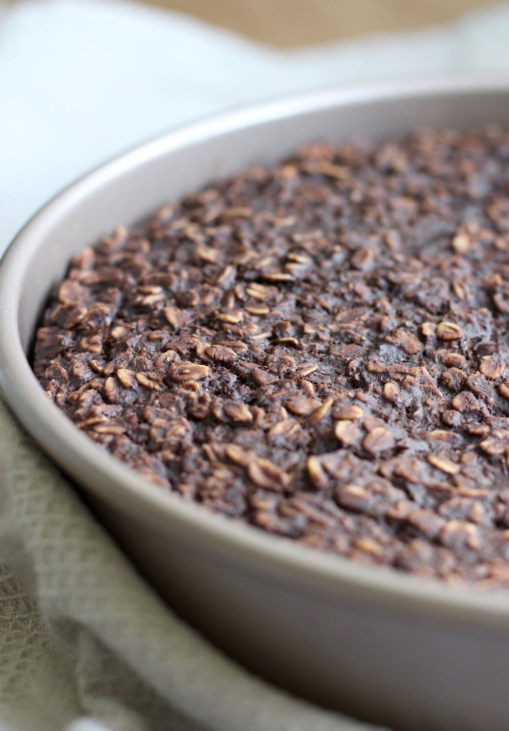 A round cake pan full of baked chocolate baked oatmeal.