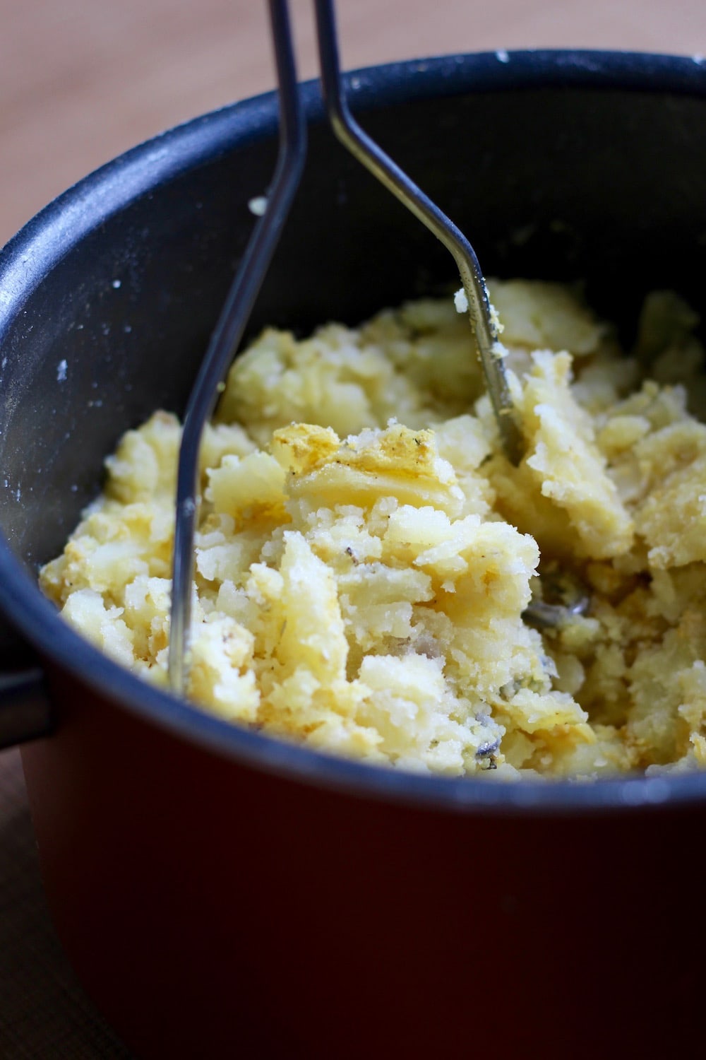 cooked potatoes being mashed for shepherd's pie