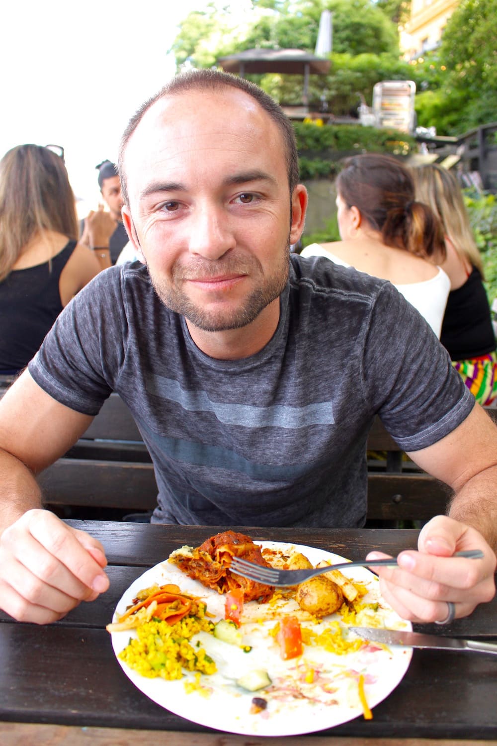 a man eating with a plateful of food