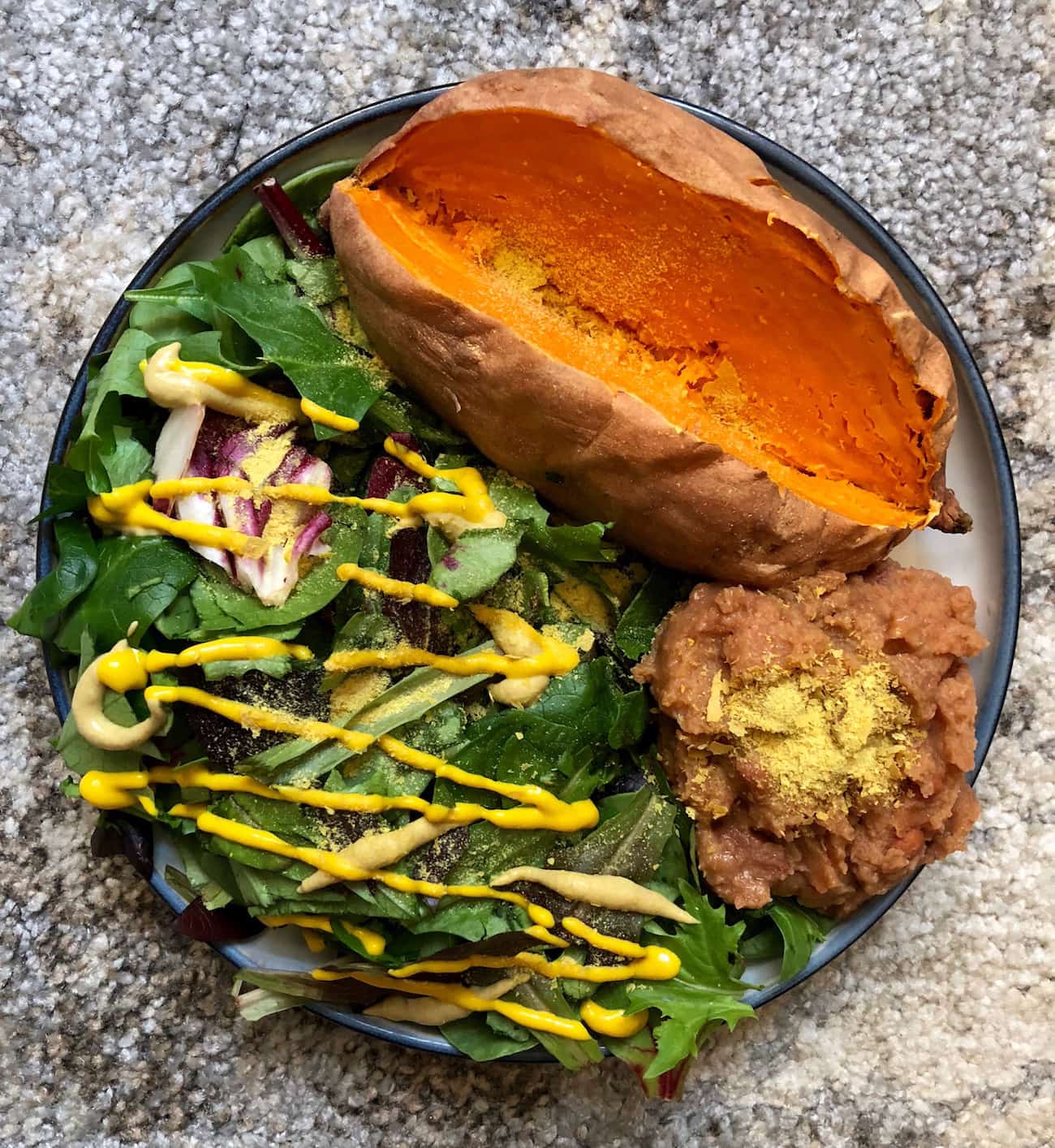Baked sweet potato with side salad and refried beans