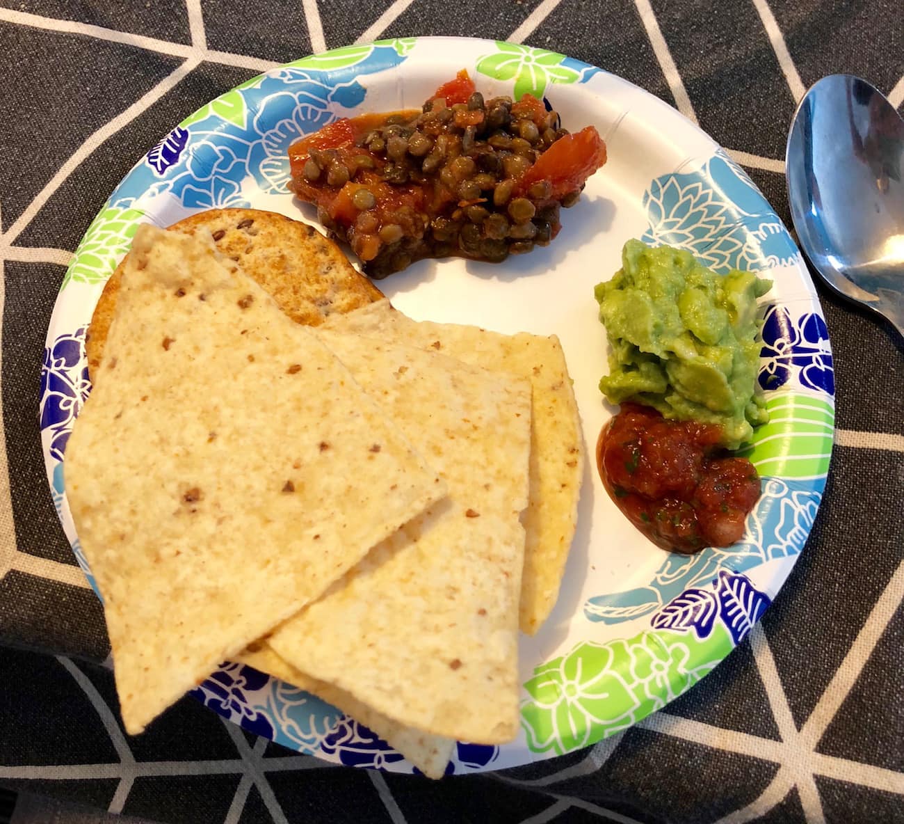 Crackers, tortilla chips, lentil bruschetta dip, guac and salsa