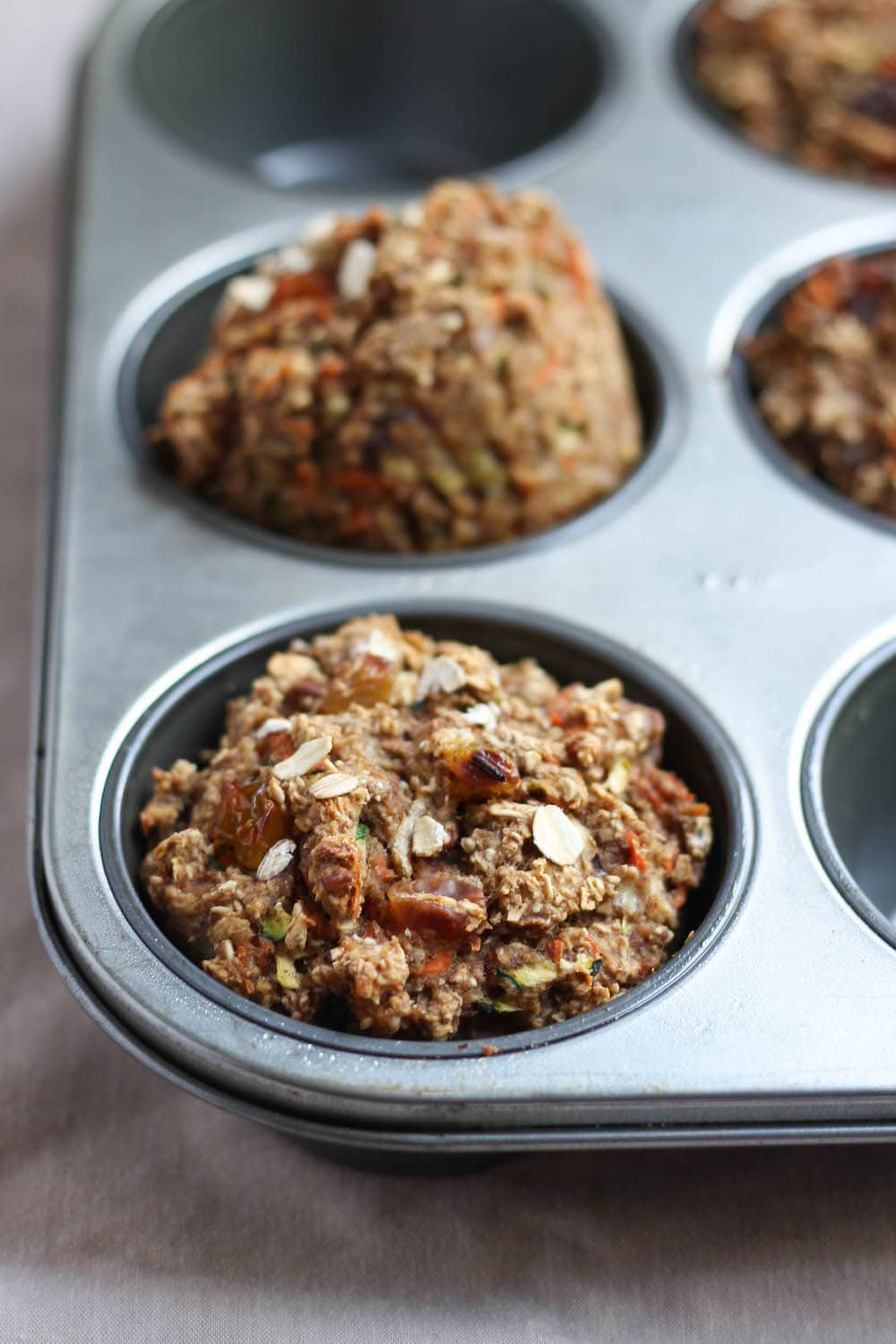 Zucchini Carrot Oatmeal Breakfast Muffins in a muffin pan