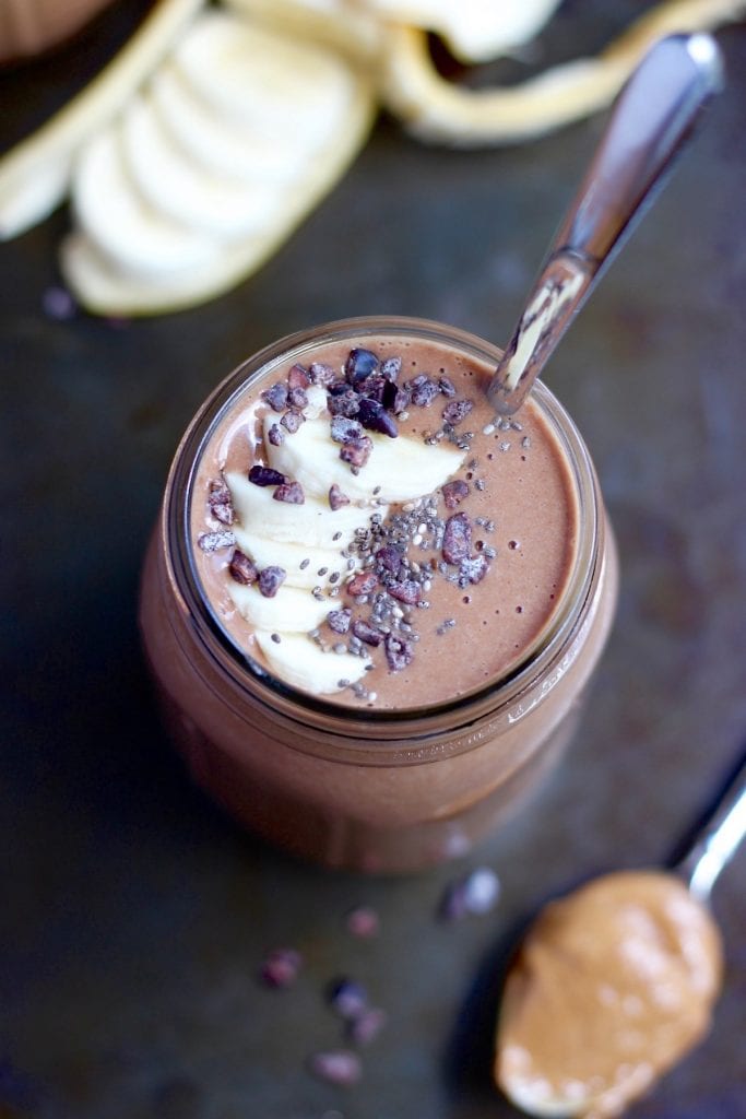 a chocolate smoothie topped with sliced banana and chia seeds