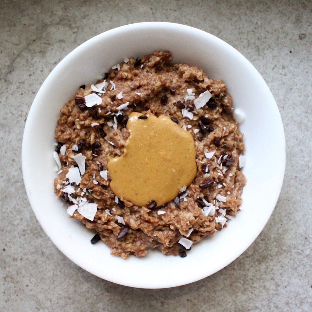 Chocolate Zucchini oatmeal made in a microwave and topped with nut butter