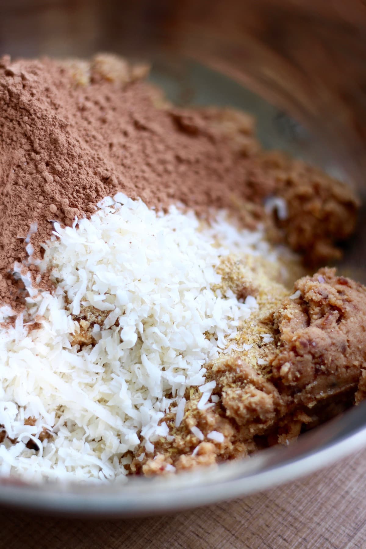 coconut flakes, cocoa powder and almond pulp in a mixing bowl