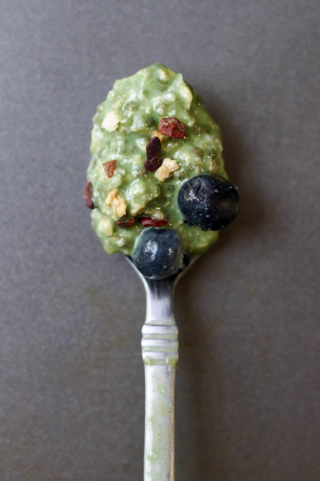 Green superfood overnight oats on a spoon