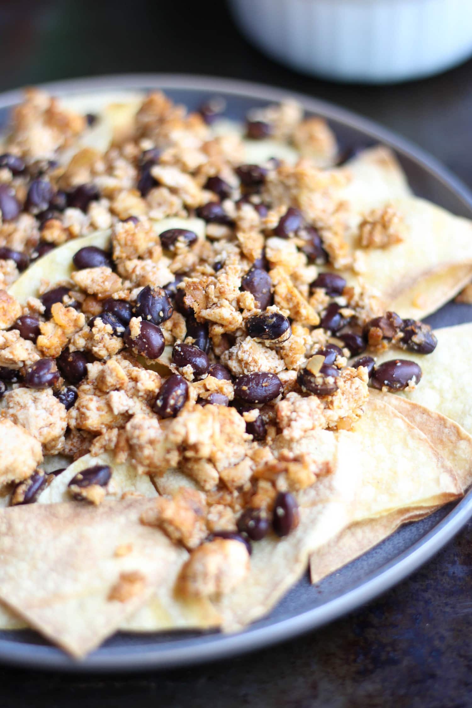 Ground taco tofu and black beans on homemade baked tortilla chips