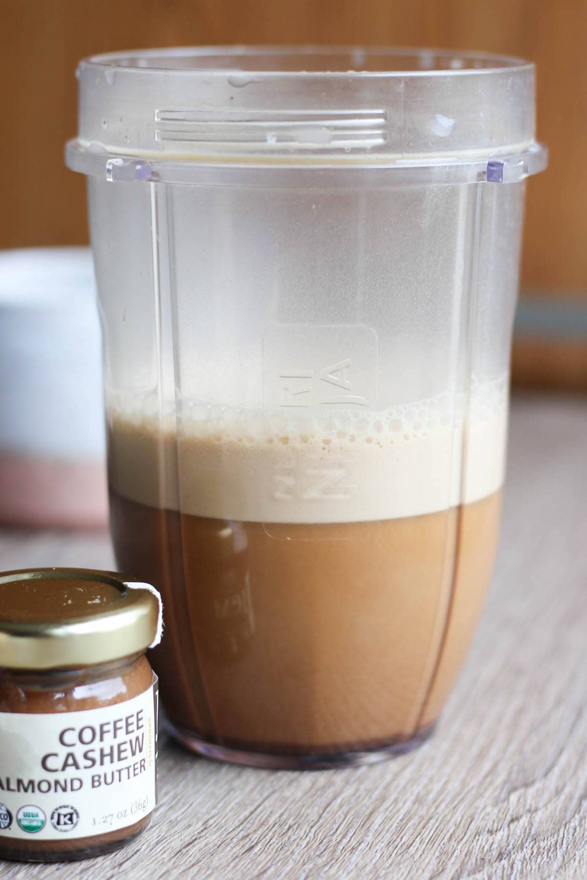 A small blender jar filled with super frothy coffee. 