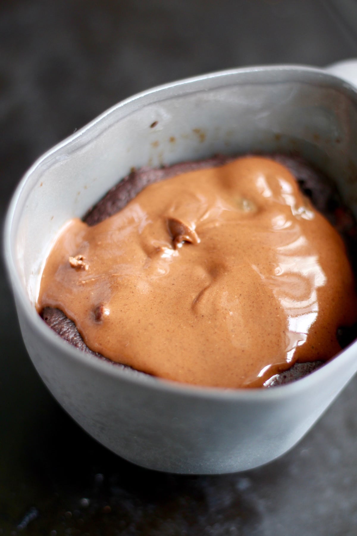 drippy peanut butter on a warm chocolate mug cake