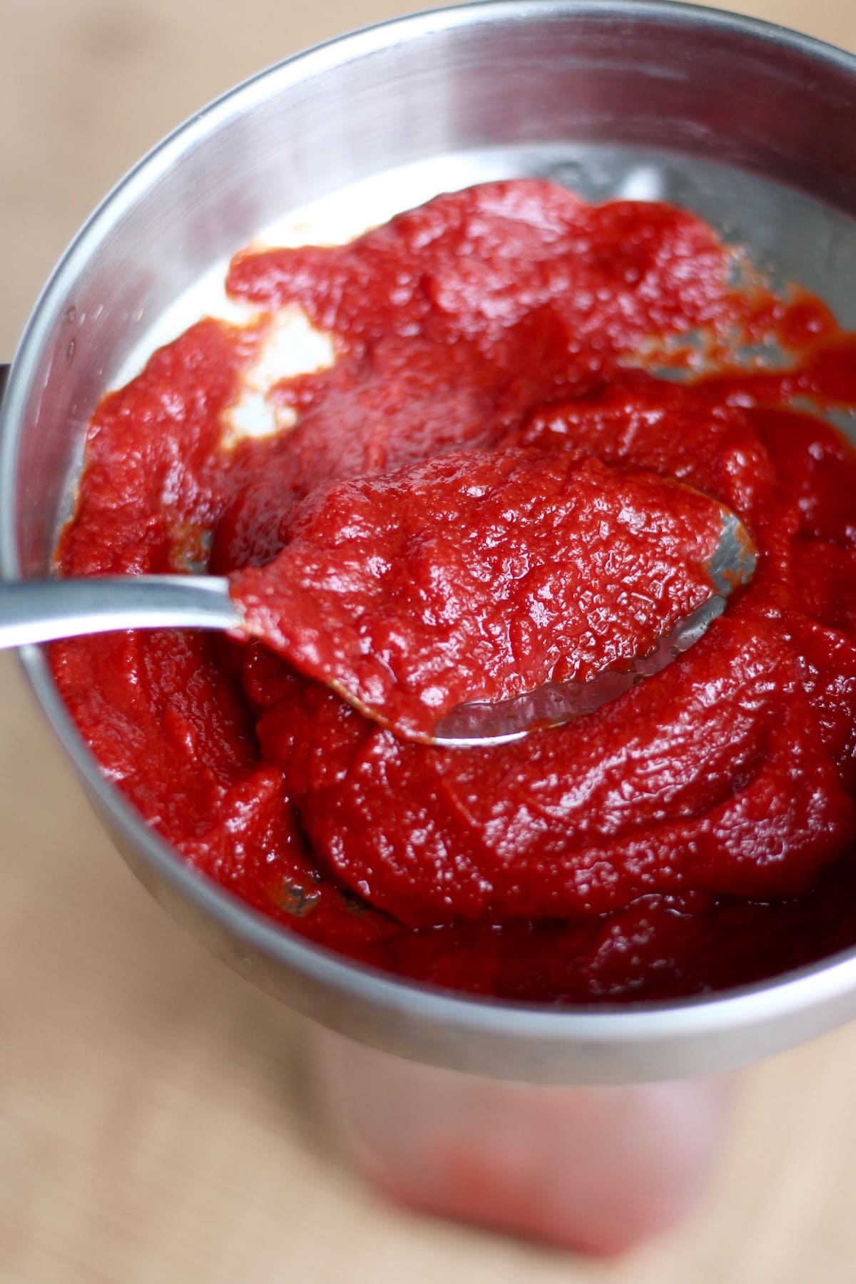 Homemade ketchup being funneled into a jar