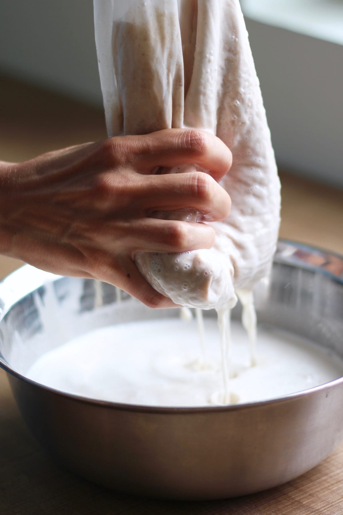 squeezing almond milk out of a nut milk bag