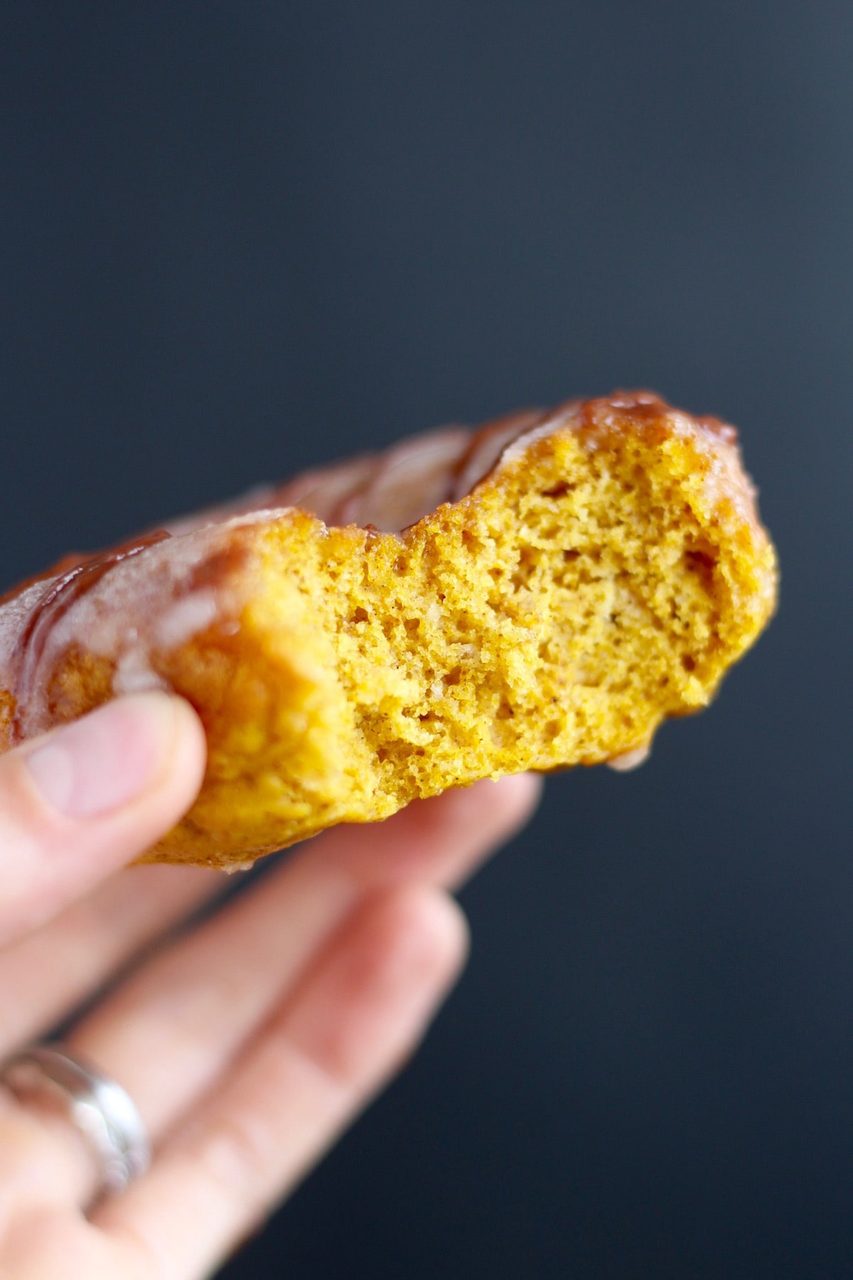 a bite taken out of a pumpkin baked donut