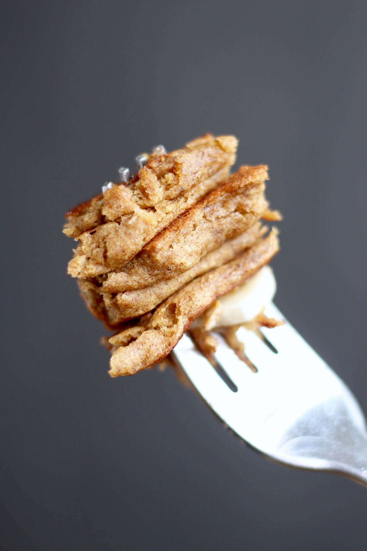 a fork stacked with a large bit of pancakes