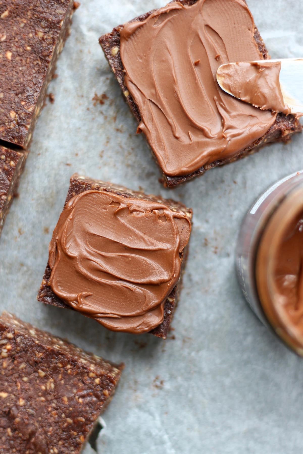 Two no bake nutella brownies being frosted with hazelnut butter