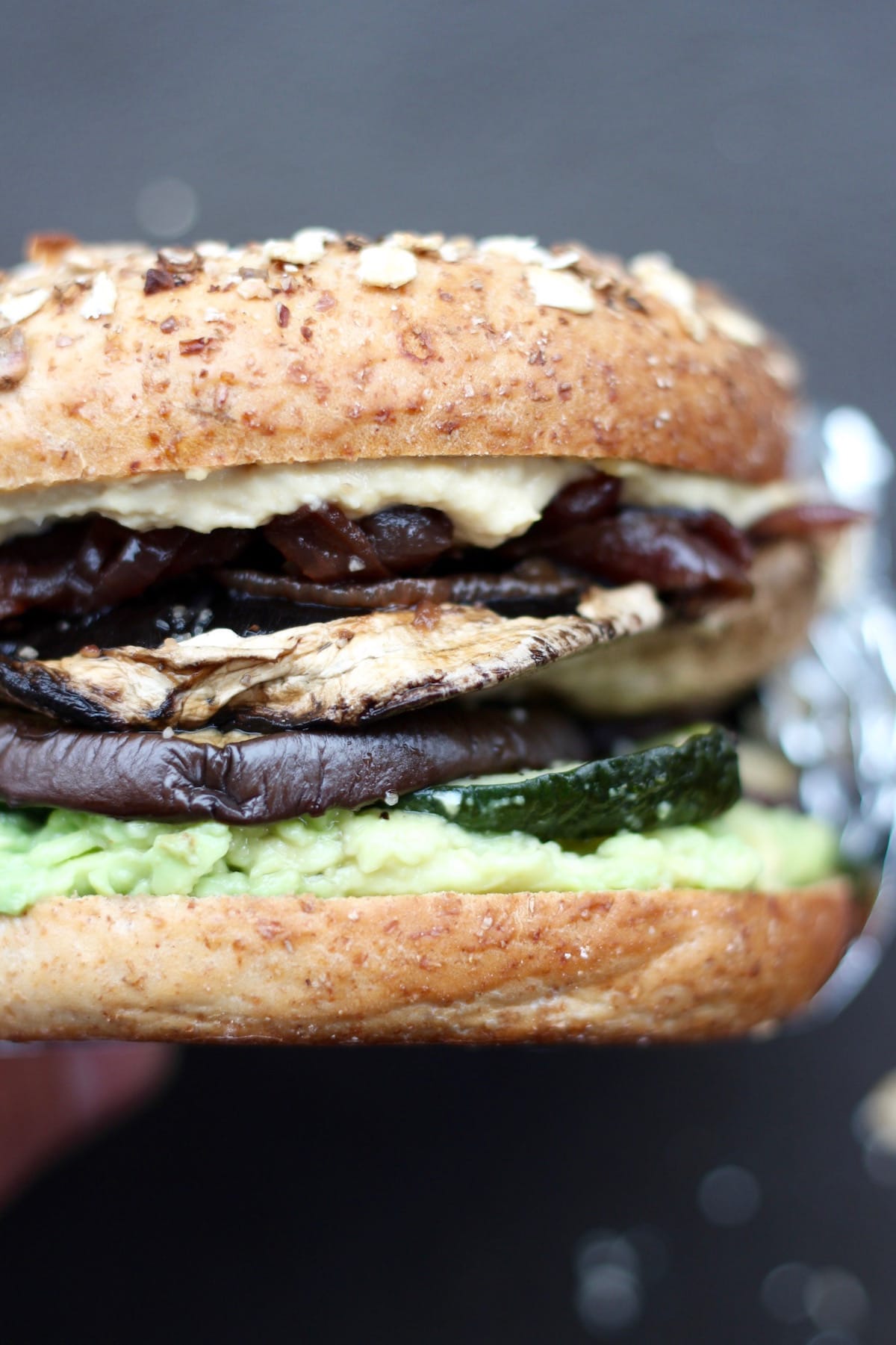 A loaded roasted veggie and hummus bagel sandwich