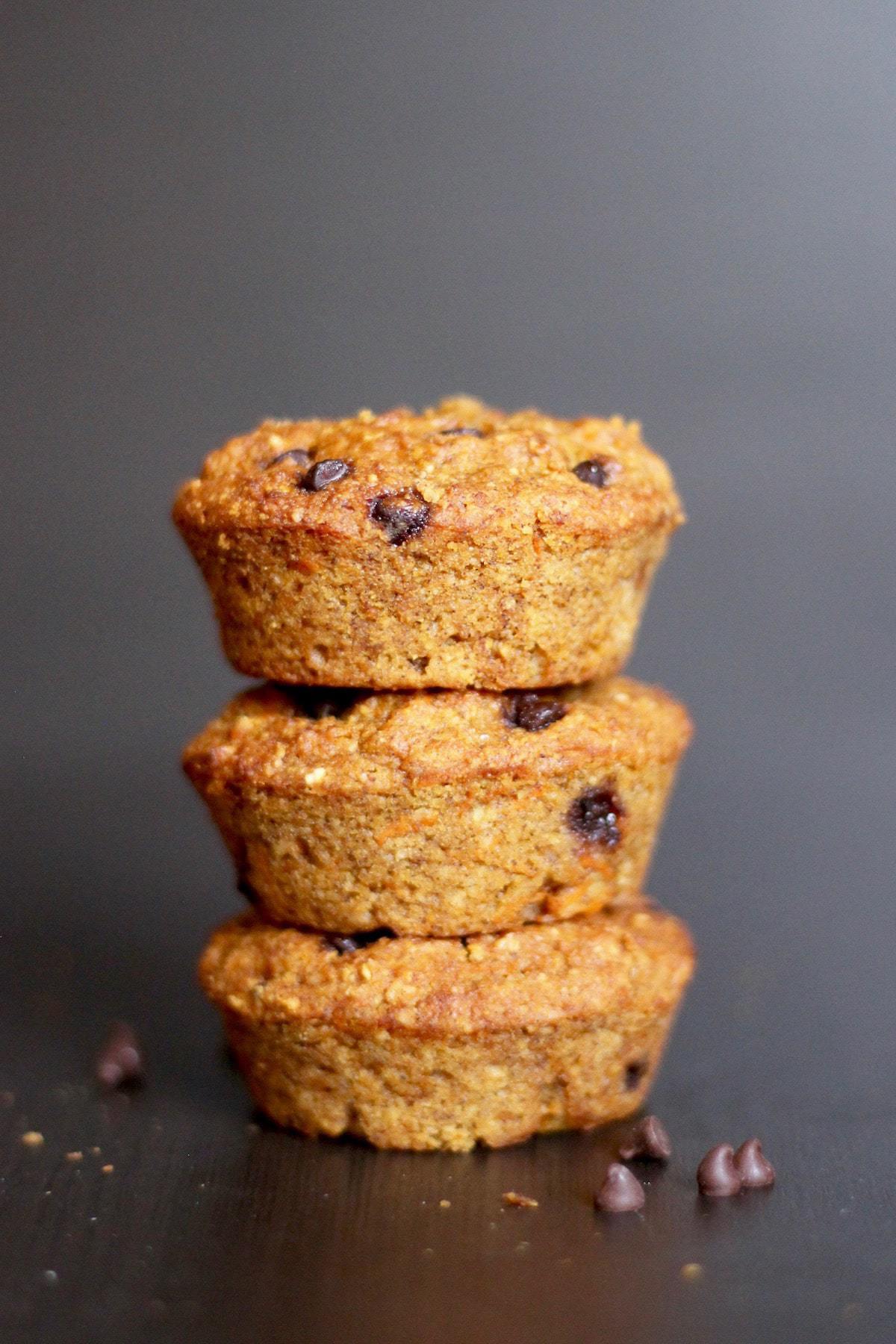 three carrot chocolate chip muffins stacked on each other