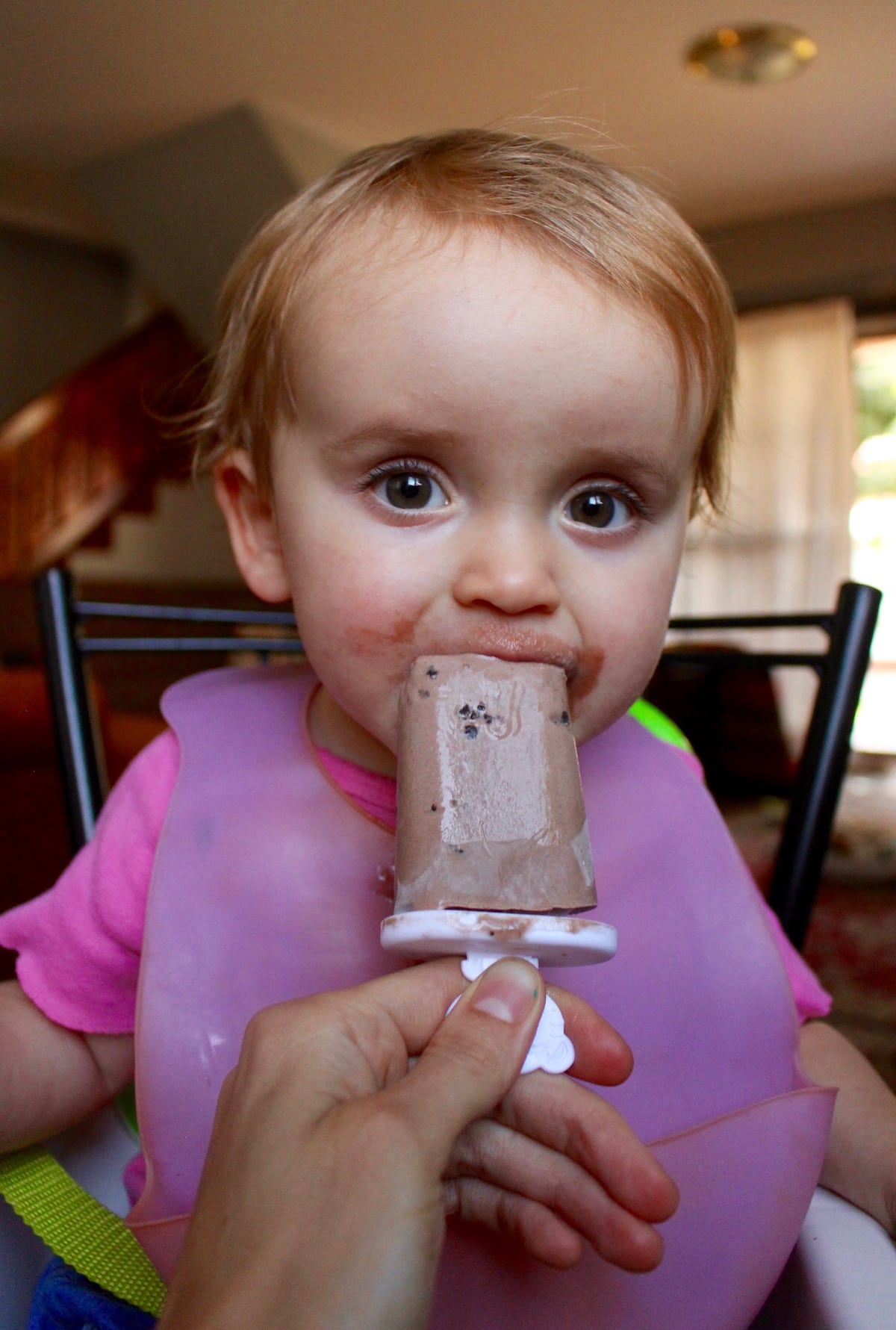 Baby girl enjoying a chocolate popsicle