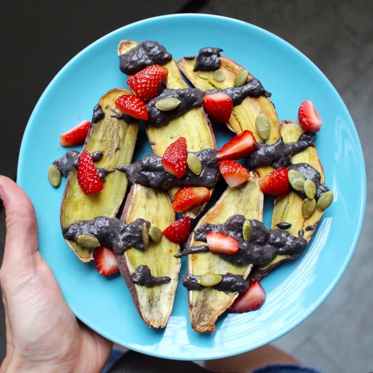 sweet potatoes topped with black tahini and berries