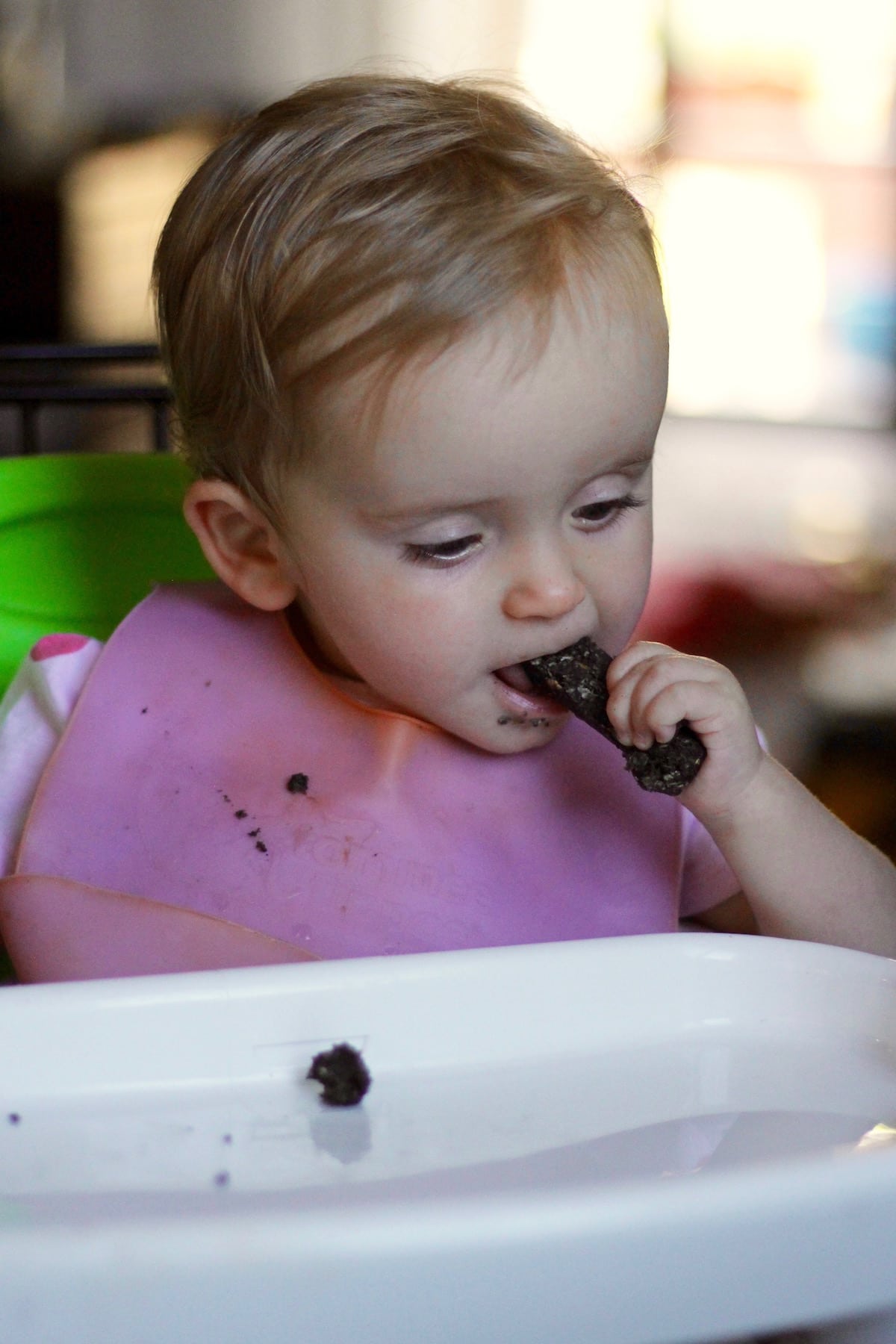 a little girl eating a homemade black tahini date bar