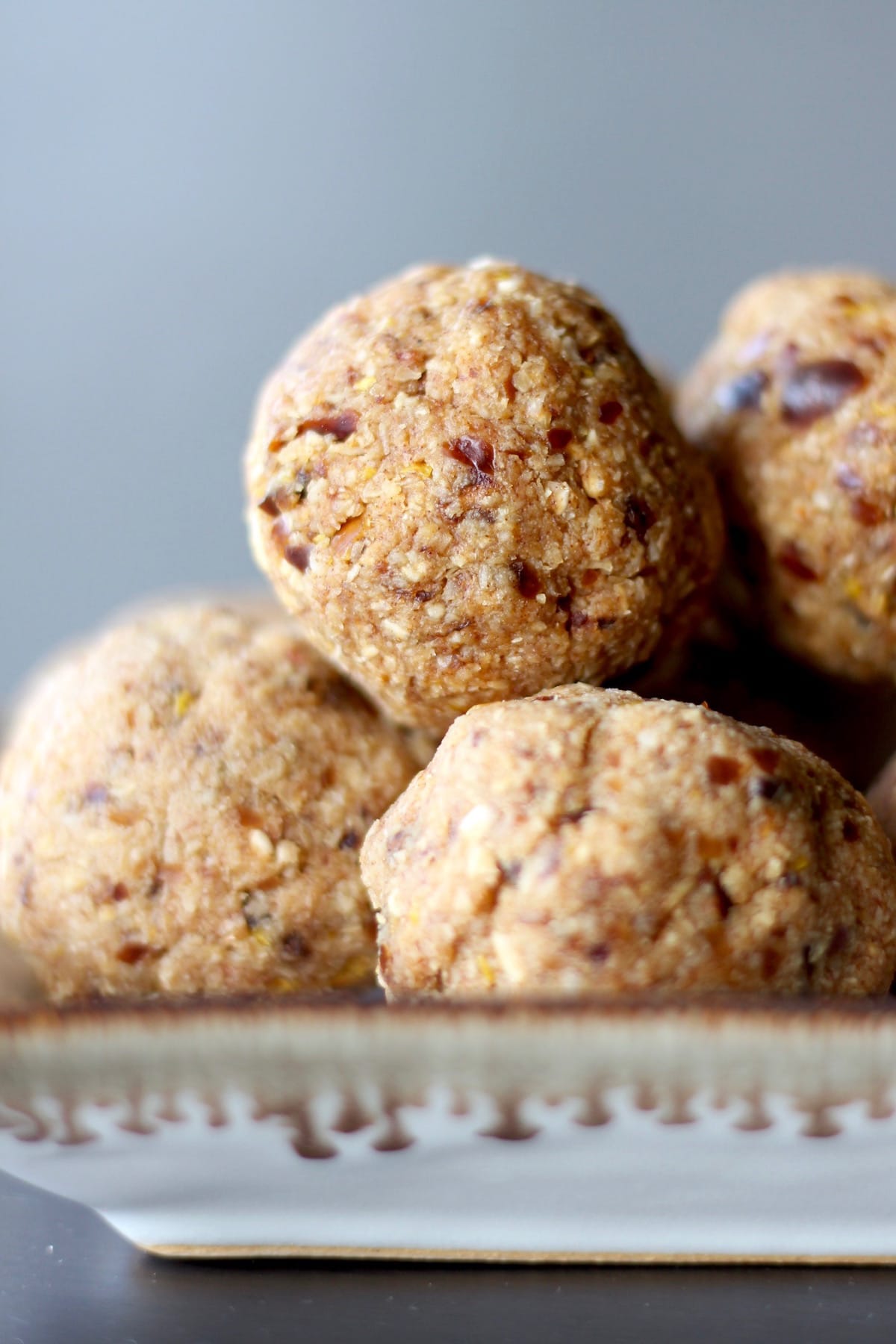 date speckled lemon energy bites stacked on a plate