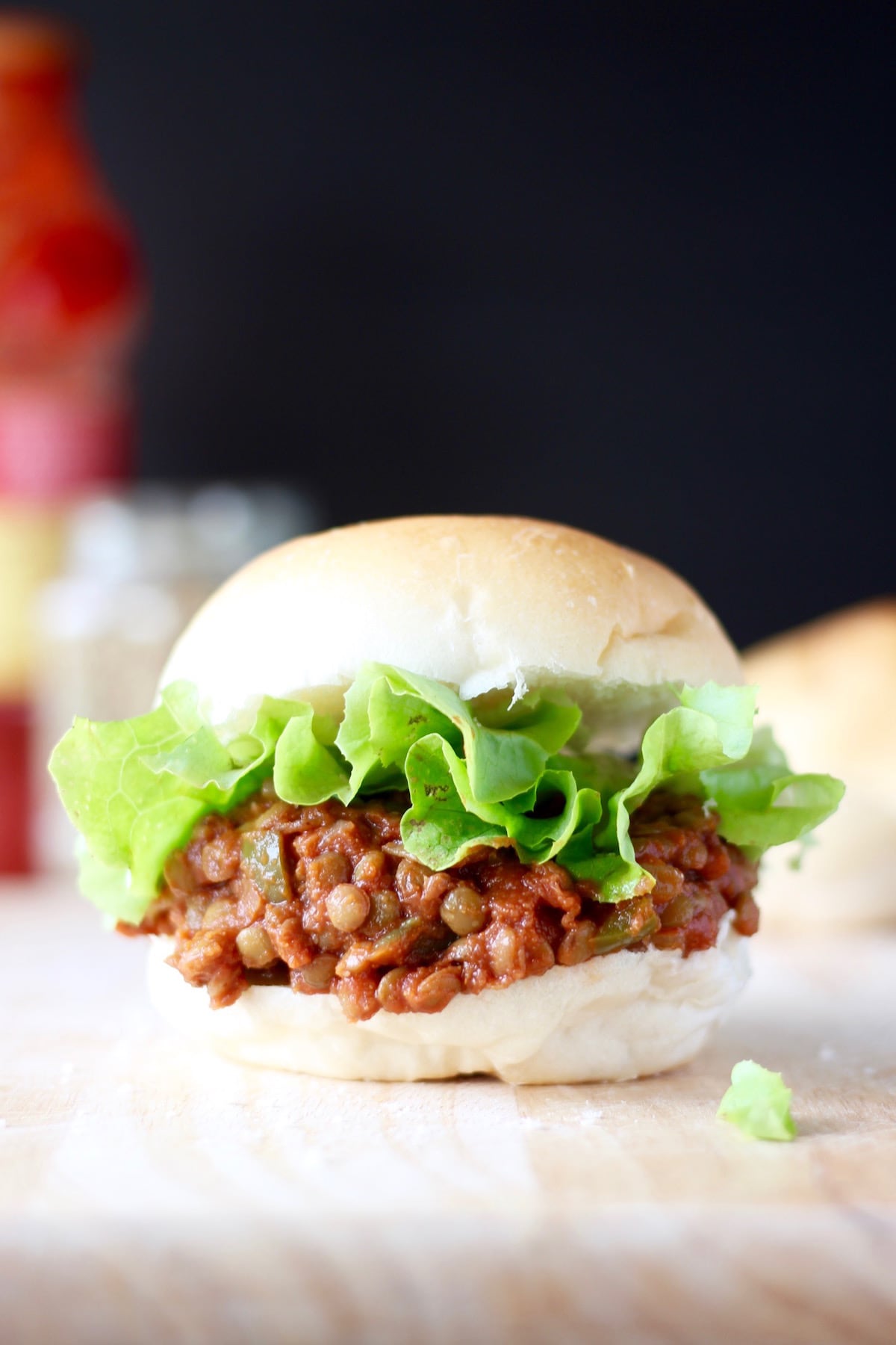 Lentil sloppy joes piled high on a hamburger bun with lettuce