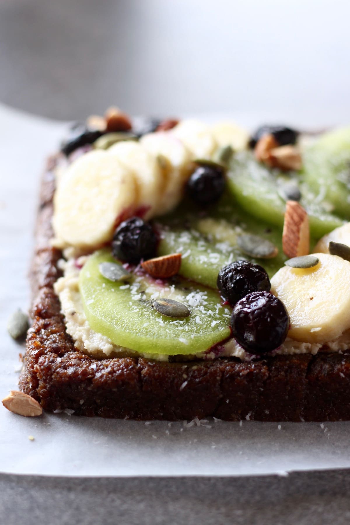 vibrant green kiwi decorating a raw fruit pizza