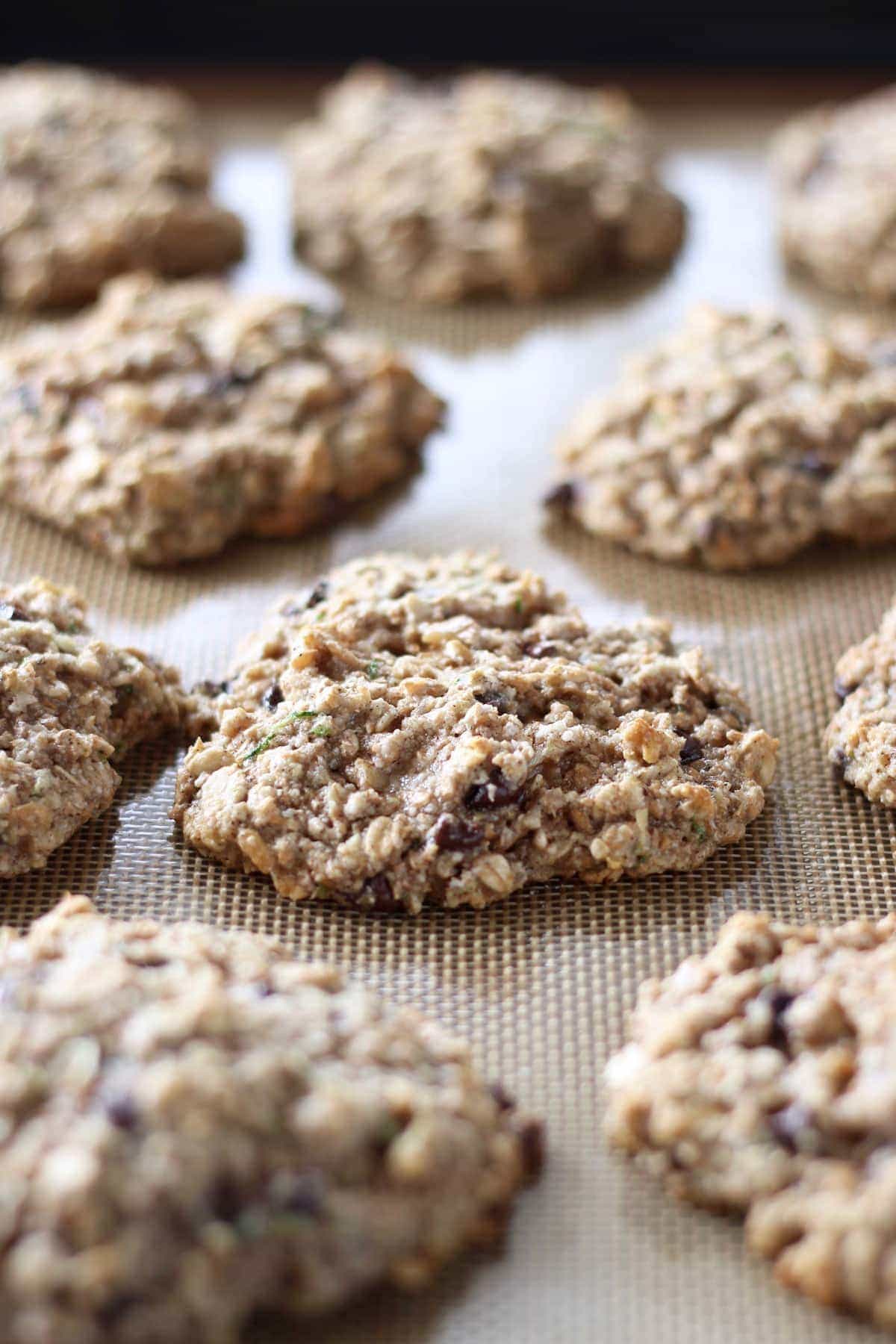 zucchini oatmeal cookies cooking on a silicone baking mat