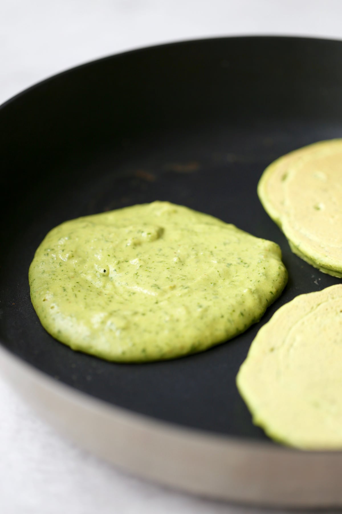 chickpea flour pancakes cooking on a skillet