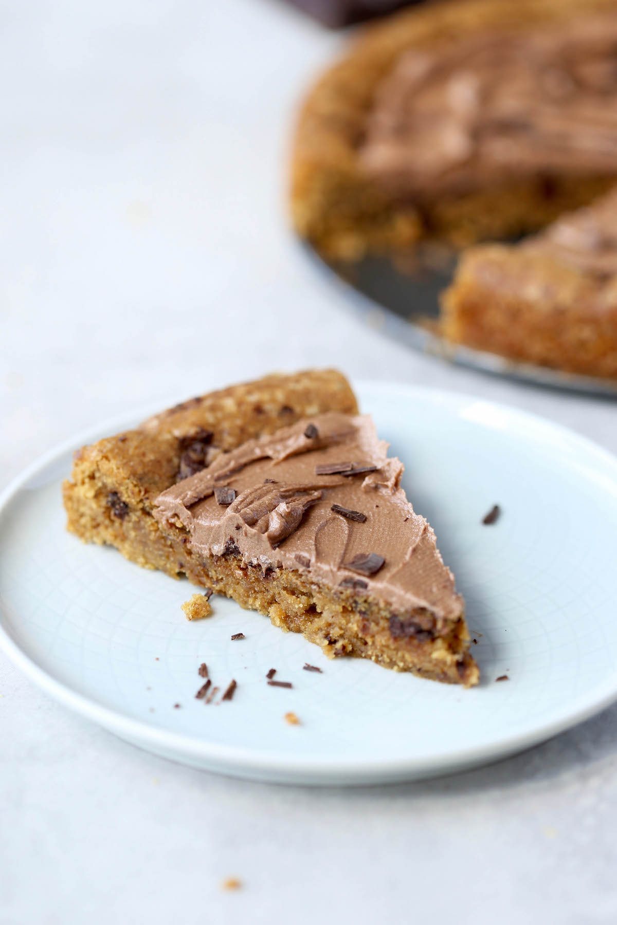 a frosted slice of cookie cake on a plate