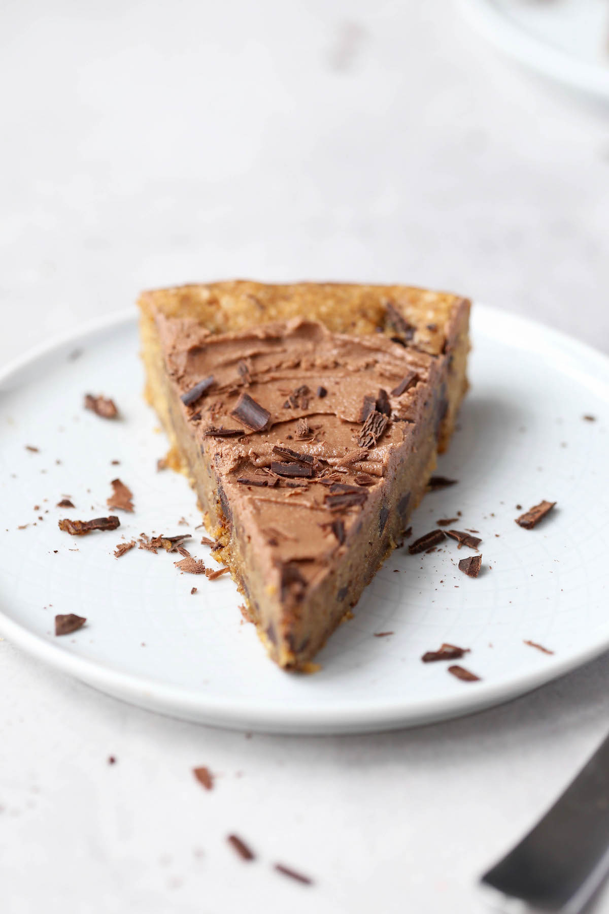 a straight on shot of a slice of frosted cookie cake