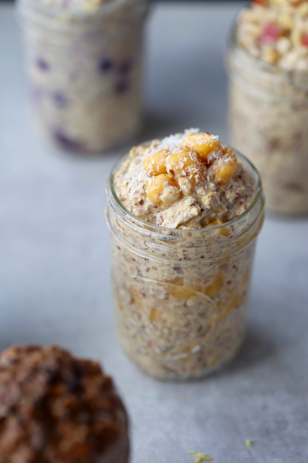 A jar of breakfast oats topped with mango