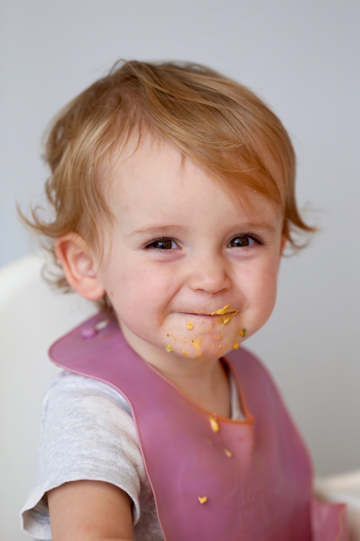 a little girl with hummus all over her mouth
